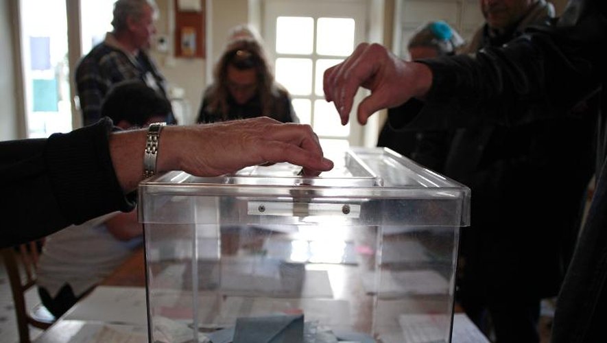 Un électeur dépose son bulletin dans l'urne le 23 mars 2014 à Monts-en-Bessin