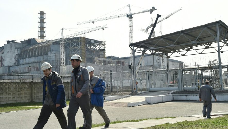 Des employés devant le sarcophage de la centrale nucléaire de Tchernoby le 8 avril 2016