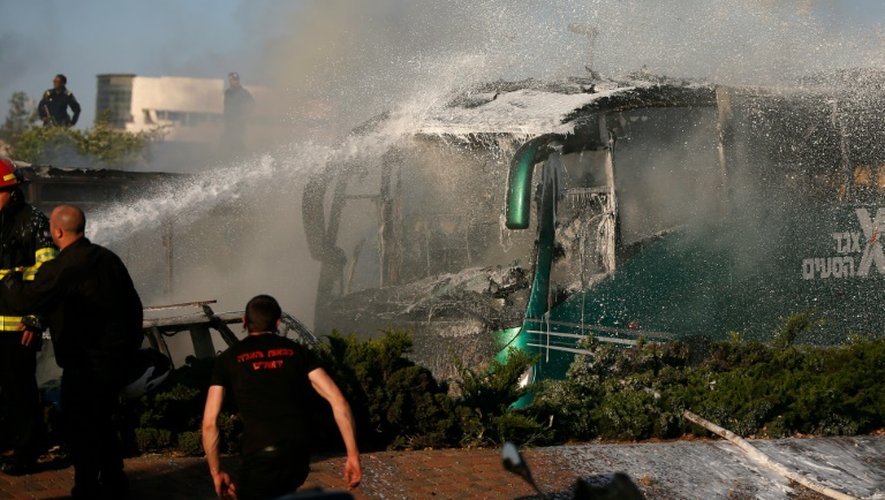 Des pompiers éteignent l'incendie d'un bus victime d'une explosition à la bombe le 18 avril 2016