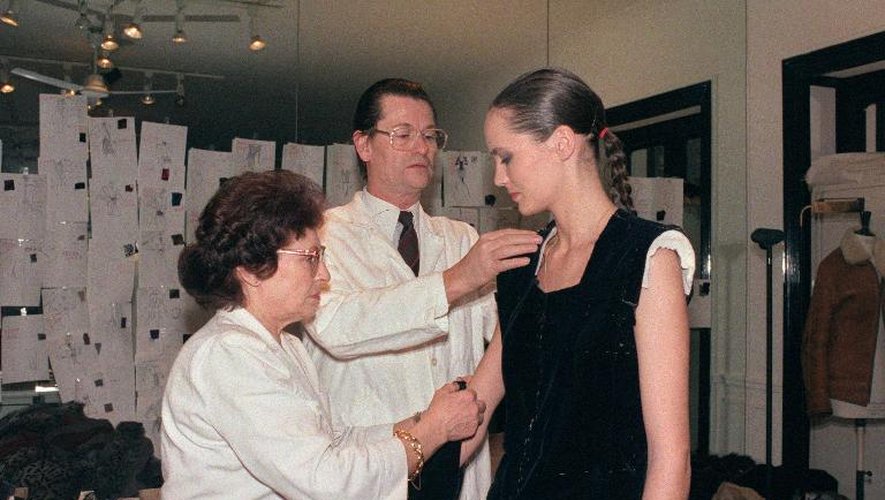 Le couturier Jean-Louis Scherrer (c) ajuste une robe sur un mannequin dans son atelier à Paris, en 1987