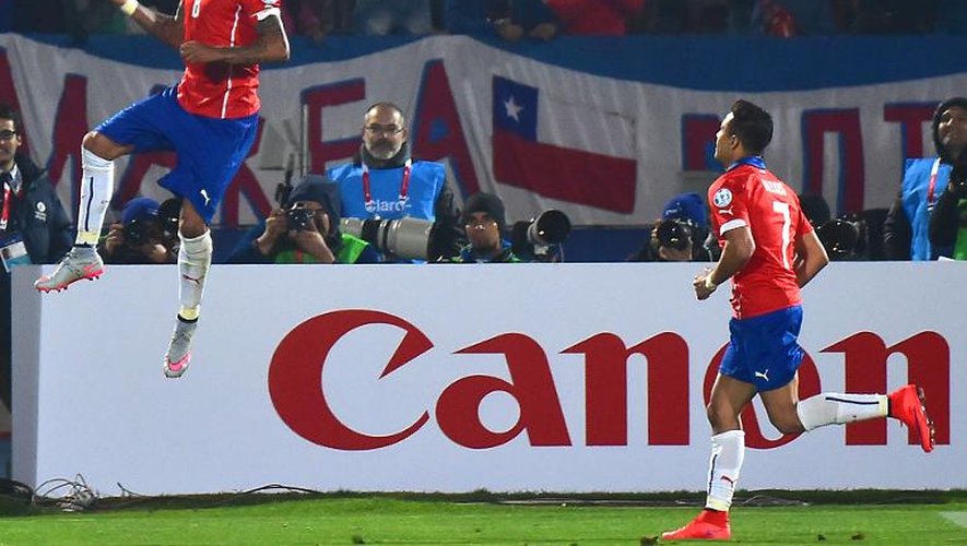 Le milieu de terrain du Chili Arturo Vidal (g) fête son penalty réussi face à l'Equateur, en ouverture de la Copa America, le 11 juin 2015 à Santiago