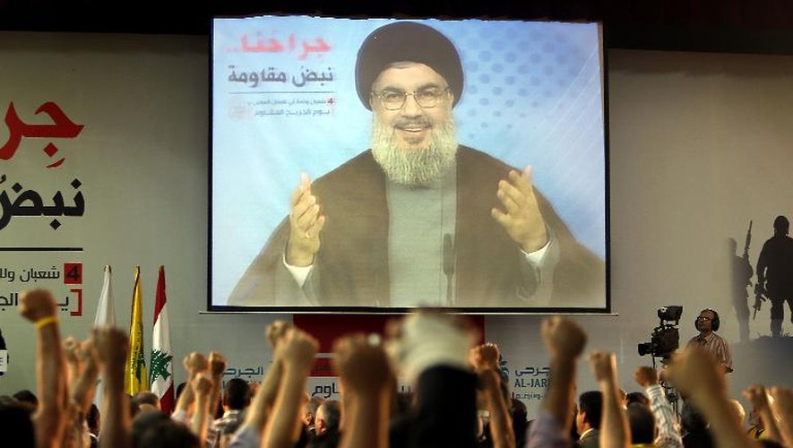 Des partisans du Hezbollah écoutent leur leader Hassan Nasrallah pendant une intervention télévisée, à Beyrouth le 14 juin 2013