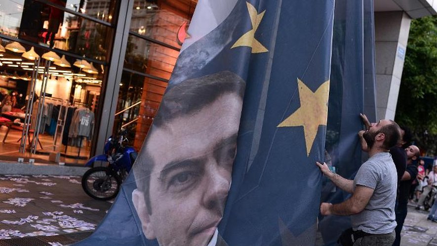 Une bannière sur laquelle apparait le Premier ministre grec Alexis Tsipras et le drapeau européen décrochée du ministère des finances à Athènes, le 11 juin 2015