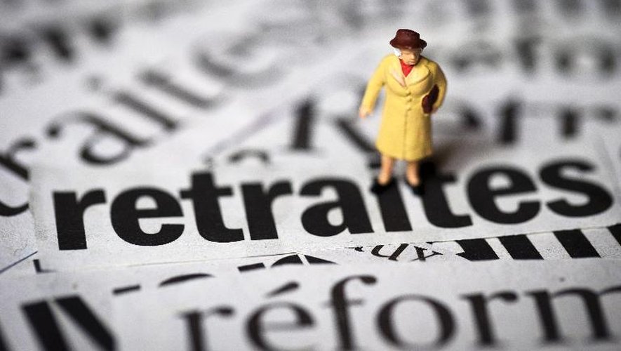 Photo prise le 19 juin 2013 à Paris, d'un personnage miniature photographié sur différentes coupures de journaux traitant du sujet de la réforme des retraites.
