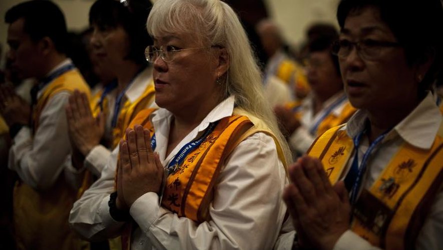 Des bouddhistes malaisiens prient pour les victimes du vol MH370, à Kuala Lumpur le 31 mars 2014