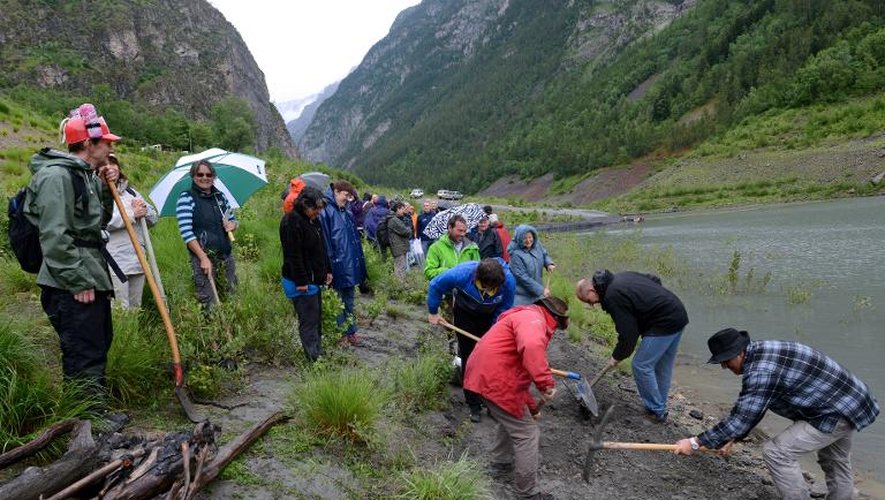 Des habitants de la vallée de la Romanche, exaspérés par deux mois d'isolement en raison d'un glissement de terrain qui a entraîné la fermeture préventive de la RD 1091, construisent une route symbolique sur la rive du lac de Chambon (Isère), le 12 juin 2015
