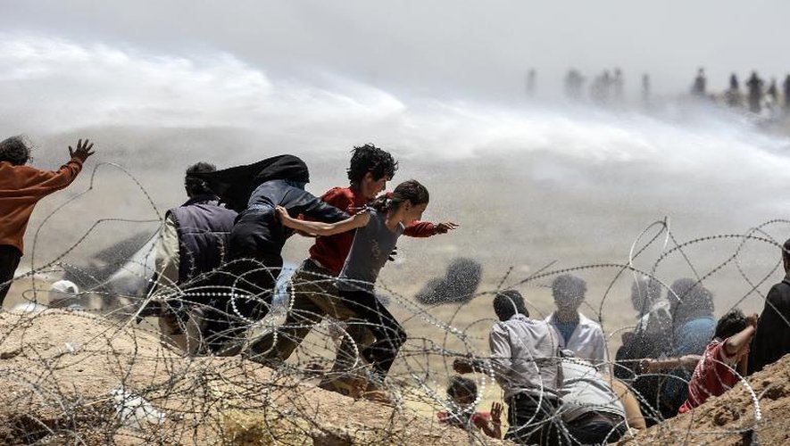 Les forces de sécurité turques repoussent des réfugiés syriens tentant de franchir la frontière, le 13 juin 2015 au point de passage frontalier de Akçakale