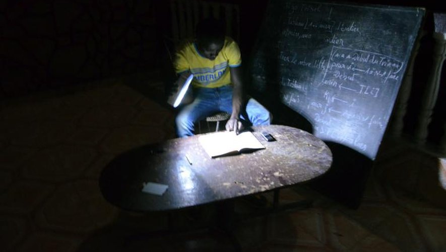 Un étudiant révise ses cours à la lueur d'une lampe de poche à Niamey, le 18 juin 2013