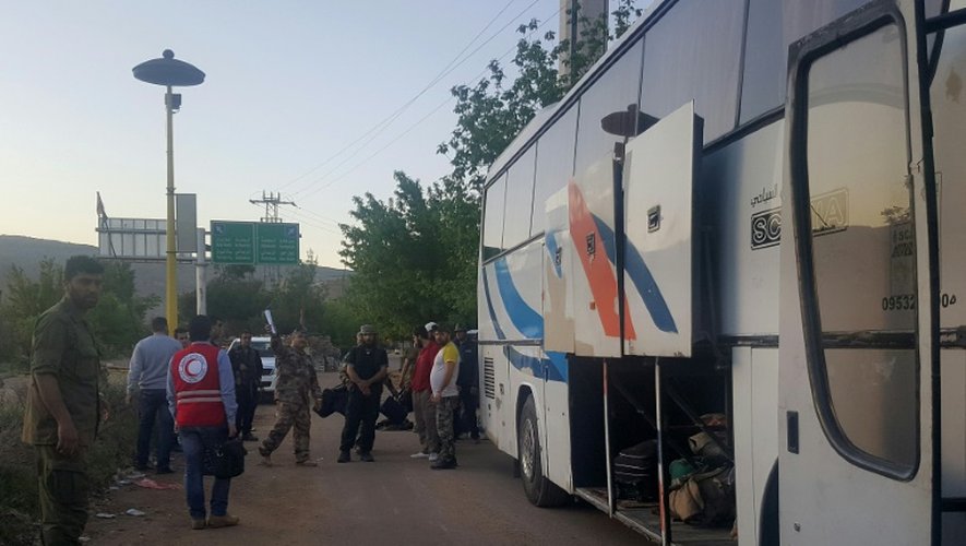 Des Syriens montent dans un bus transportant des blessés le 20 avril 2016 dans la ville assiégée de Madaya