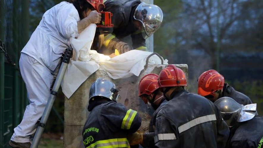 Des pompiers tentent de dégager un enfant d'un bloc de béton, le 2 avril 2014 à Roubaix