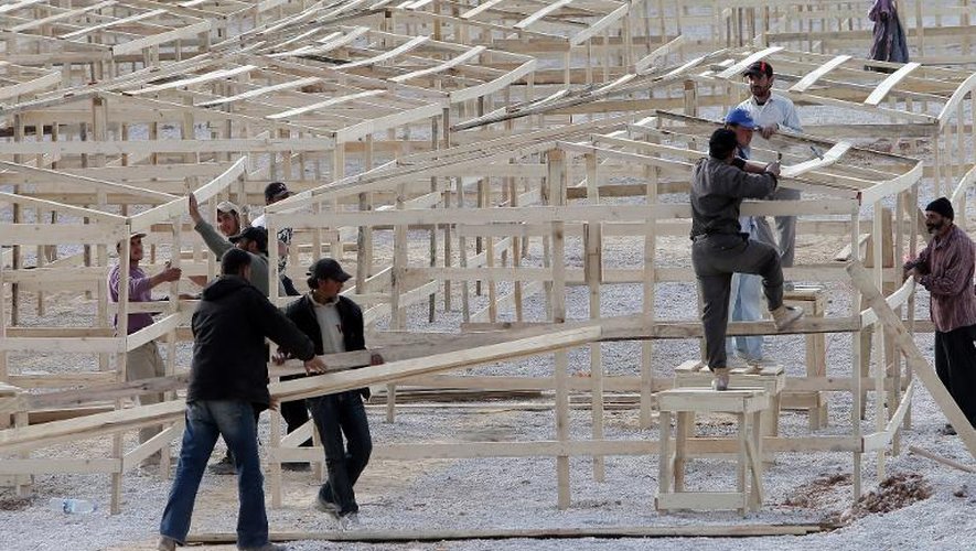 Des Syriens construisent des armatures en bois dans un nouveau camp de réfugiés de la ville libanaise d'Aarsal, près de la frontière syrienne, le 28 mars 2014