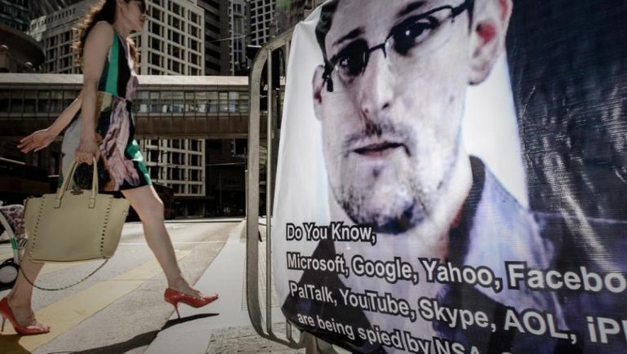 Une femme passe devant une affiche en soutien d'Edward Snowden, le 18 juin 2013 à Hong Kong