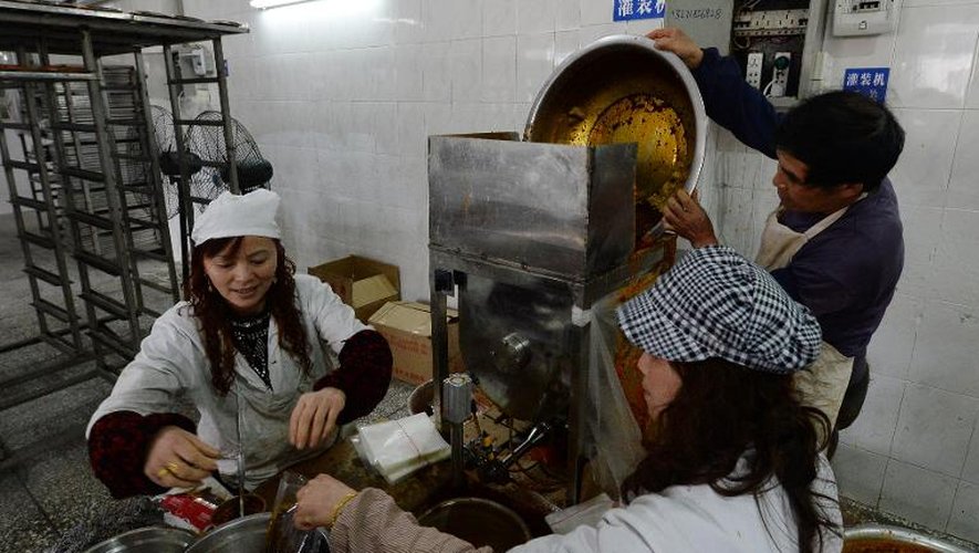 Des ouvriers préparent de la sauce à fondue sichuanaise, à base de piments fermentés, à l'atelier-musée de Chongqing, le 22 février 2014