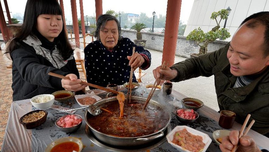 Des employés dégustent la très populaire fondue sichuanaise au "musée de la fondue" de Chongqing le 22 février 2014