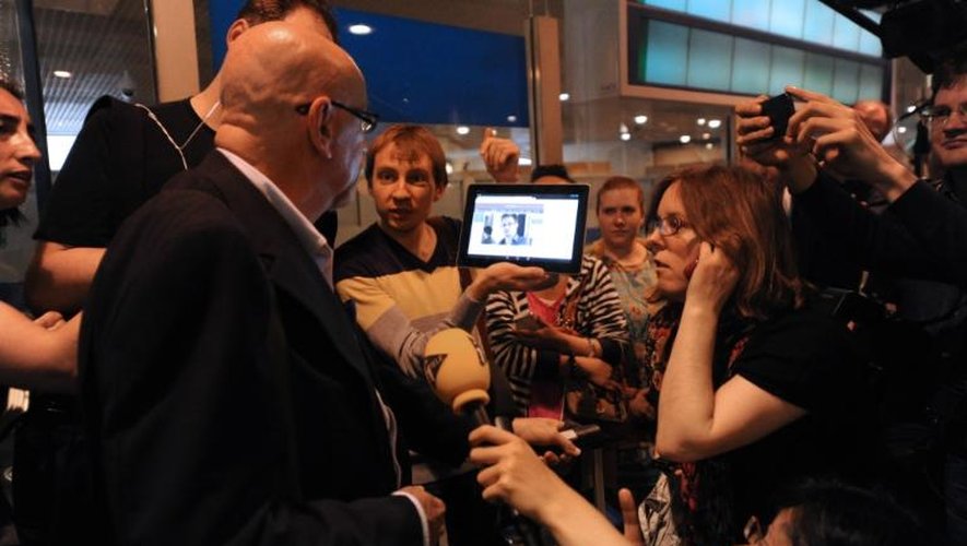 Un journaliste montre à un passager une photo d'Edward Snowden, dans le hall d'arrivée de l'aéroport de Moscou-Cheremetievo, le 23 juin 2013