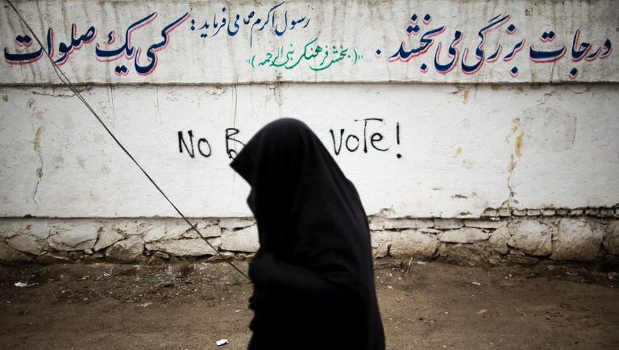 Une Afghane passe devant des graffitis à Hérat le 3 avril 2014