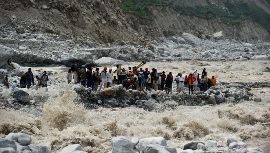 Des pèlerins attendent sur la rive d'un fleuve en crue d'être secourus, le 23 juin 2013 à Govindghat, en Inde