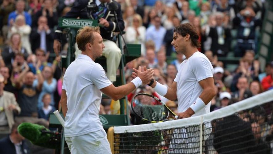Le Belge Steve Darcis (gauche) serre la main de l'Espagnol Rafael Nadal après leur rencontre lors du tournoi de Wimbledon, le 24 juin 2013
