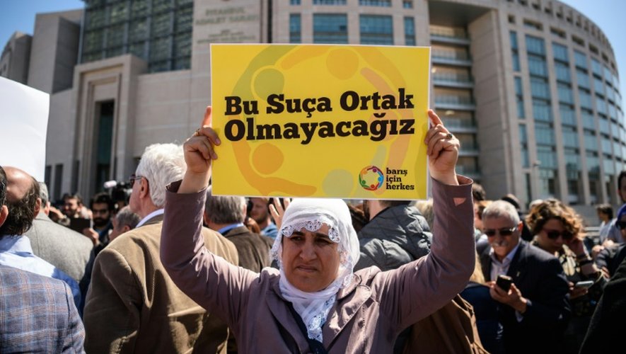 Une sympathisante de quatre universitaires turcs tient une affiche "Nous ne voulons pas être associés à ce crime" devant le tribunal d'Istanbul, le 22 avril 2016