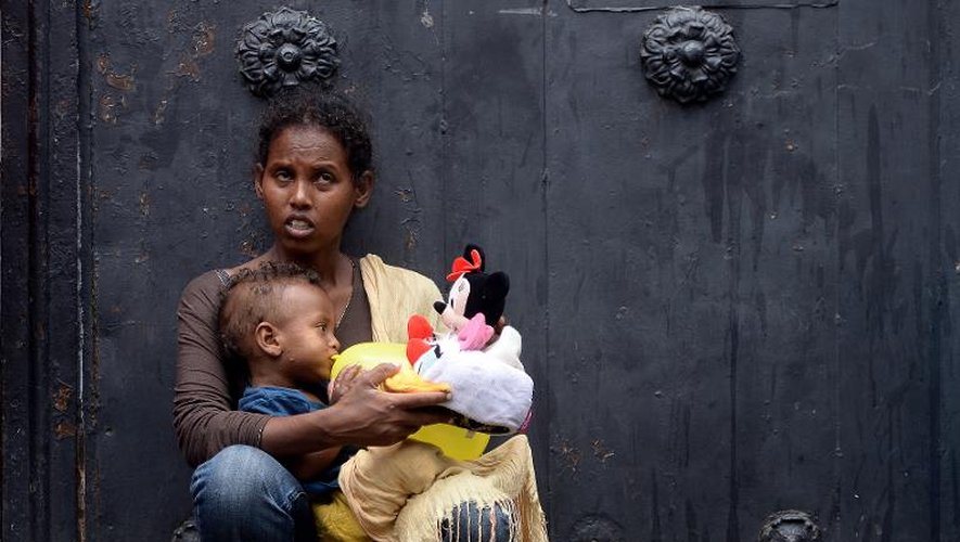 Une mère porte son enfant devant un centre d'immigration à Rome, le 14 juin 2015