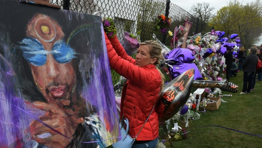 Une fan attache des fleurs en hommage à Prince à Minneapolis, le 22 avril 2016