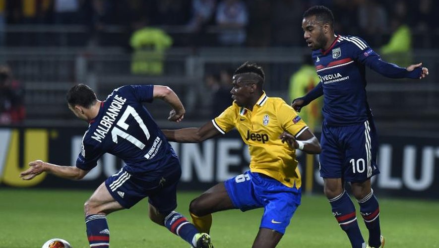 Le milieu de terrain de la Juventus Paul Pogba, marqué par les Lyonnais Steed Malbranque et Alexandre Lacazette, le 3 avril 2014 à Lyon