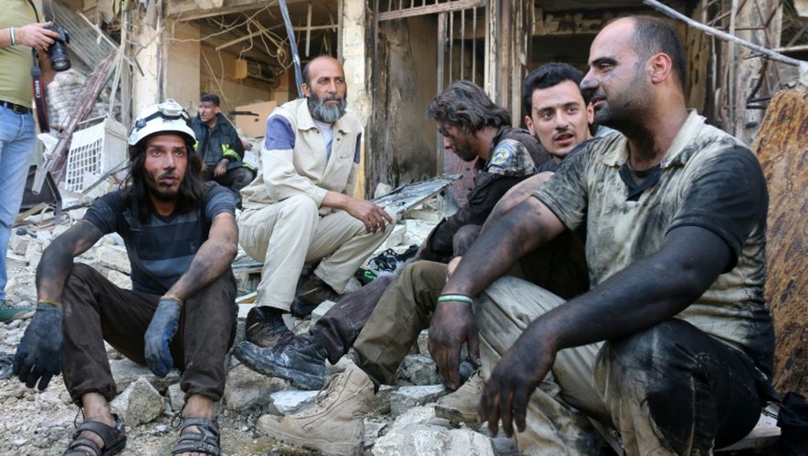 Des bénévoles du service de défense civil syrien se reposent après un bombardement dans un quartier rebelle d'Alep, le 23 avril 2016