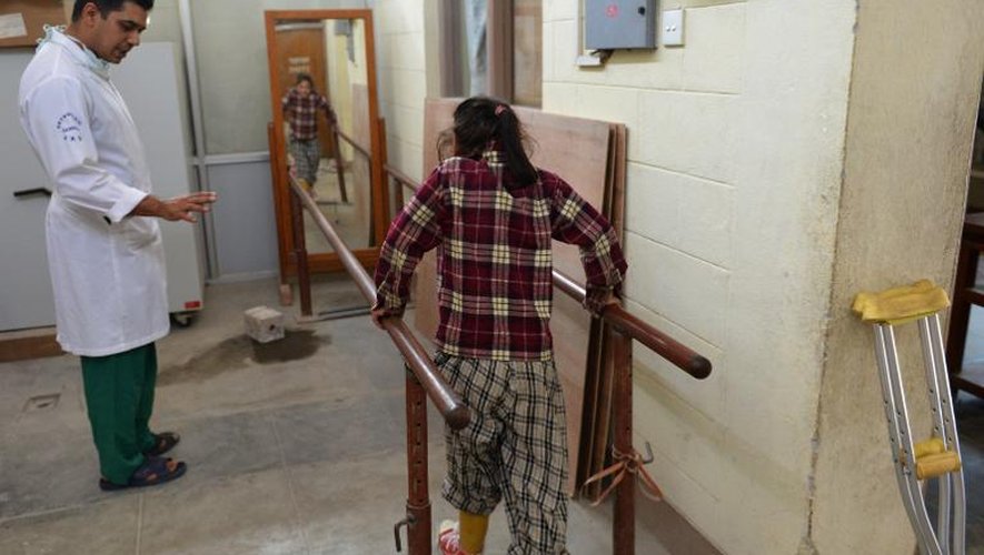 Maya Gurung surveillée par un médecin alors qu'elle s'entraîne à marcher avec une prothèse dans l'hôpital de Banepal près de Katmandou le 3 juin 2015