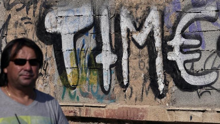 "Time" ("du temps"): graffiti peint le 15 juin 2015 sur un mur d'Athènes, avec le "e" final sous forme de symbole de l'Euro