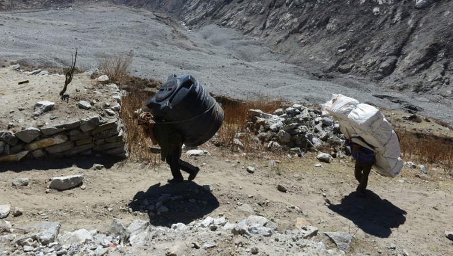 Des porteurs avec différents matériaux sur le dos qui doivent servir à reconstruire le village de  Langdang au Népal, le 6 avril 2016