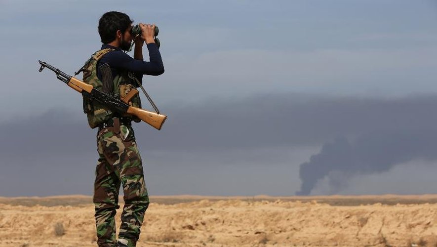Un combattant kurde observe  la bataille contre les forces du groupe Etat islamique près de Tikrit, en Irak, le 8 mars 2015