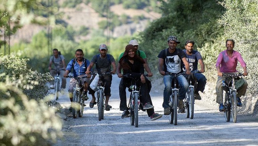 Un groupe de migrants à vélo, le 15 juin 2015 près de la ville de Demir Kapija, en Macédoine, en route vers la Serbie