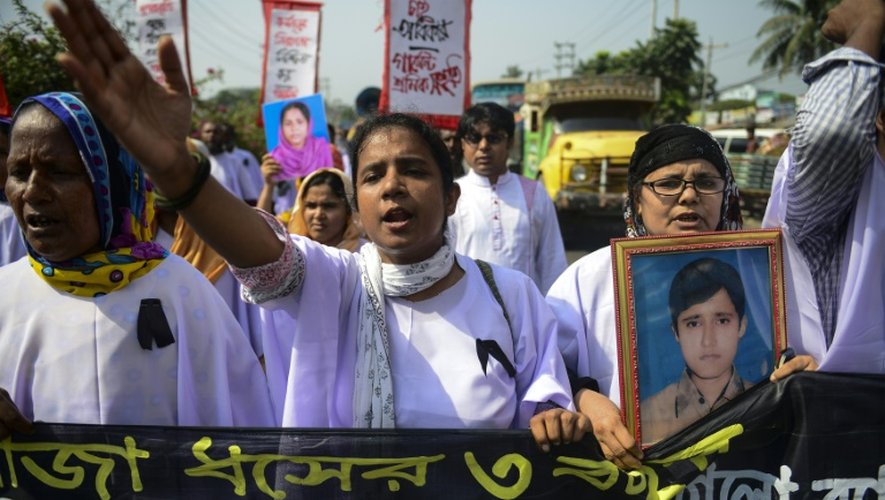 Des ouvriers du textile et des survivants du Rana Plaza défilent aux abords du lieu de la catastrophe qui a fait plus de 1.100 morts en 2013, le 24 avril 2016 à Savar dans la banlieue de Dacca
