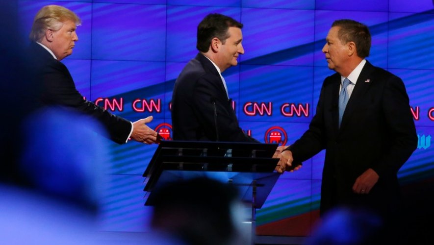 Donald Trump (g), le sénateur du Texas Ted Cruz (c), et le gouverneur de l'Ohio, John Kasich, se serrent la main après un débat sur la chaîne CNN, à Miami, en Floride, le 10 mars 2016