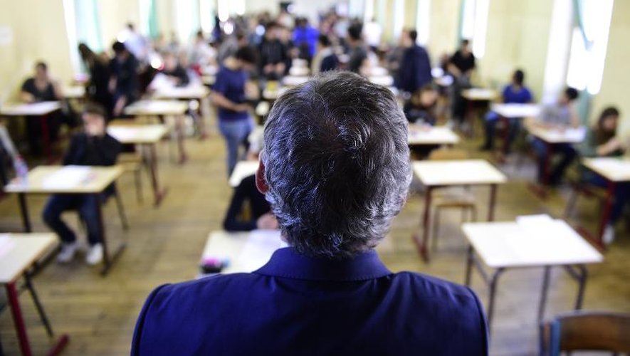 Un professeur surveille les candidats au baccalauréat qui s'installent peu avant le coup d'envoi de l'épreuve de philosophie, le 17 juin 2015 à Paris