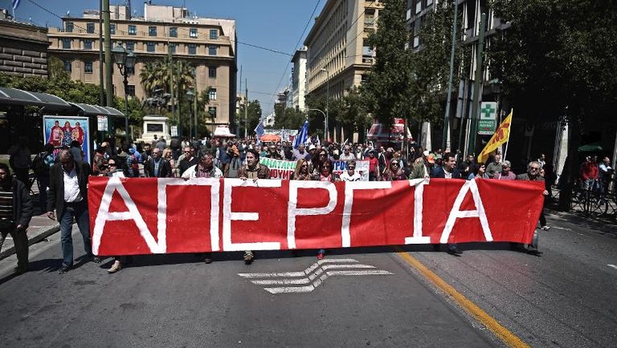 Des manifestants grecs brandissent une banderole portant l'énorme inscription "Grève" lors d'une grève générale de 24 heures le 9 avril 2014, à Athènes