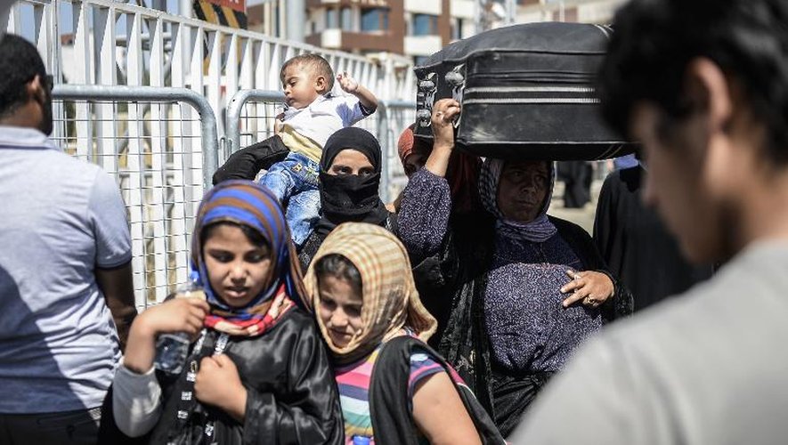 Des réfugiés syriens en Turquie retournent, le 17 juin 2015, vers la ville syrienne de Tall Abyad