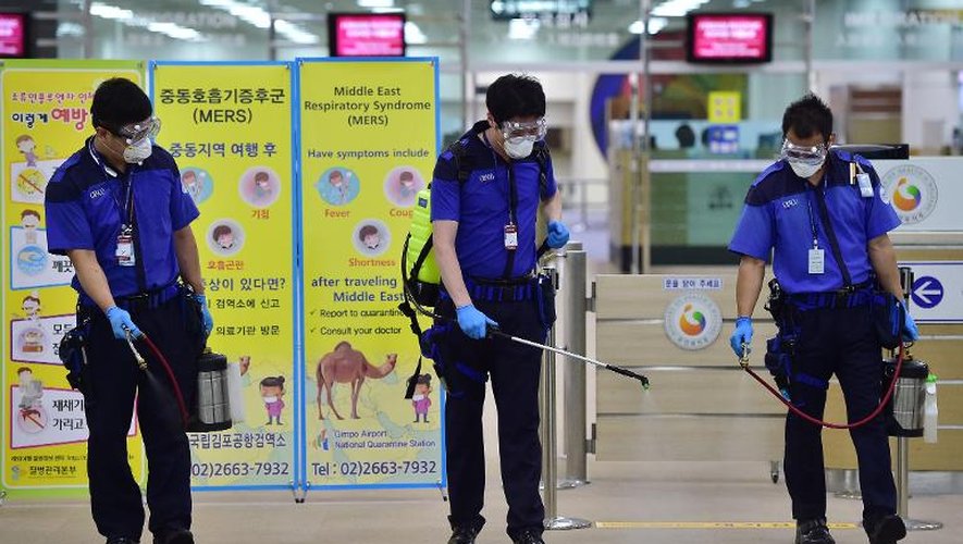 Des employés coréens pulvérisent un antiseptique dans les locaux des douanes à l'aéroport international de Séoul, le 17 juin 2015