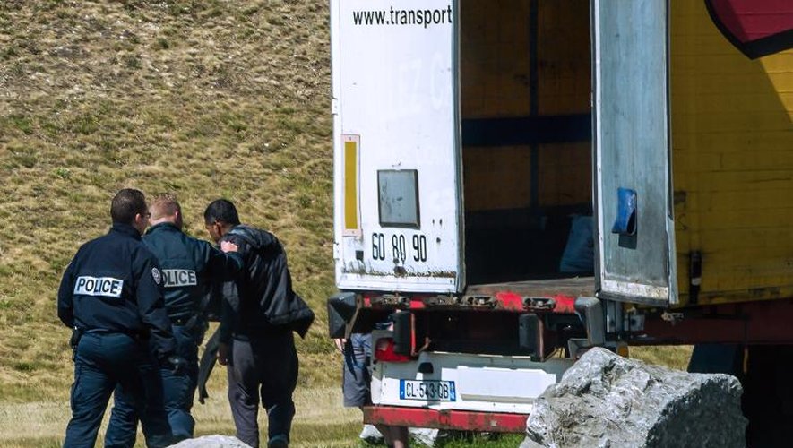 Des policiers sortent un migrant d'un camion dans lequel il avait trouvé refuge, au port de Calais le 16 juin 2015