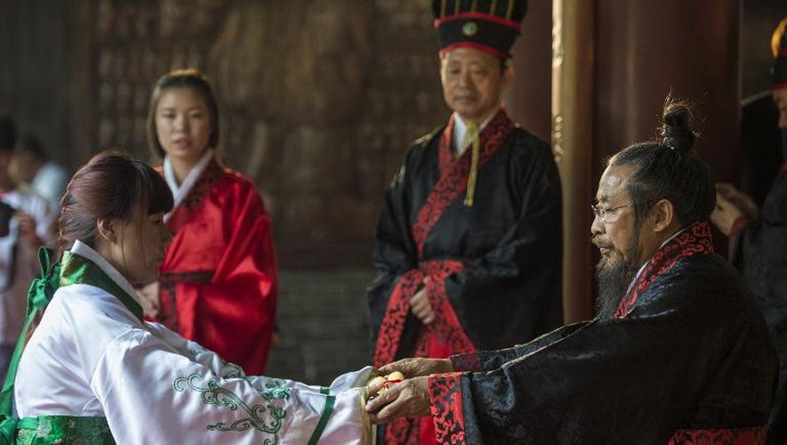 Le doyen Zhen Zhongyi (d)remet son diplôme à une étudiante, lors d'une cérémonie dédiée au grand penseur Confucius, à L'Académie des beaux arts du Hebei, à Xinle en Chine, le 16 juin 2015