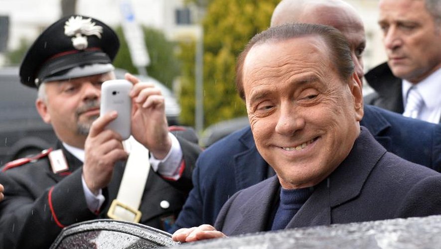 L'ex chef du gouvernement italien Silvio Berlusconi à son arrivée à l'aéroport Fiumicino près de Rome, le 25 mars 2014. Le justice se penche jeudi sur sa requête d'effectuer des travaux d'intérêt général après sa condamnat