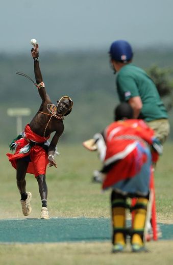 Un membre de l'équipe de cricket des "Guerriers massaï" (g) lors d'un tournoi organisé pour attirer l'attention sur le sort du dernier rhinocéros blanc du Nord, dans la réserve kényane d'Ol Pejeta, le 14 juin 2015
