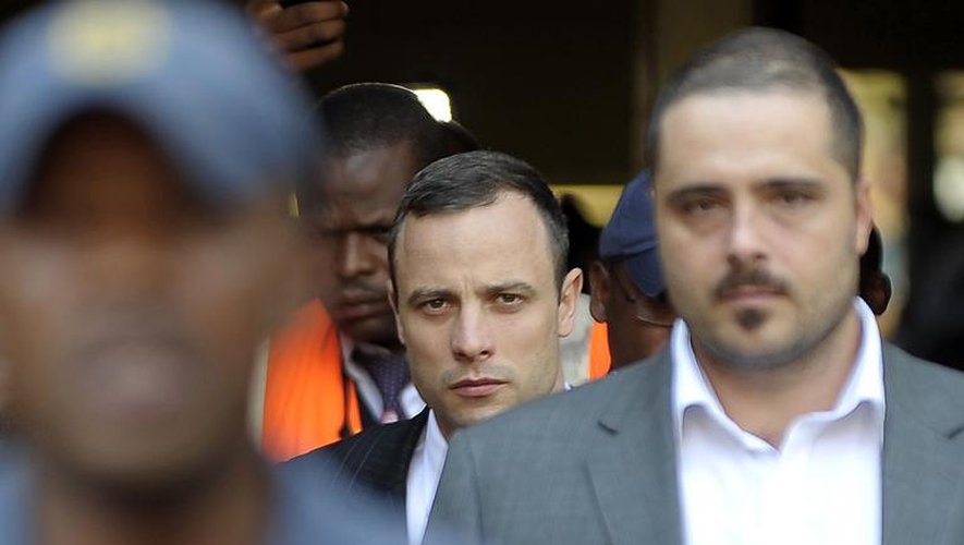 La star handisport Oscar Pistorius (centre) quitte le tribunal de Pretoria le 11 avril 2014
