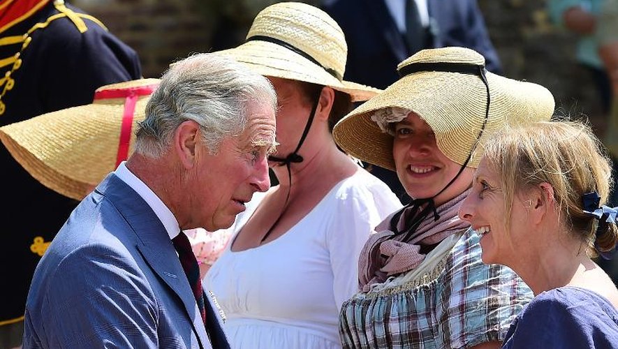 Le prince Charles salue des femmes vêtues de costumes d'époque lors de la cérémonie de ré-ouverture de la ferme d'Hougoumont