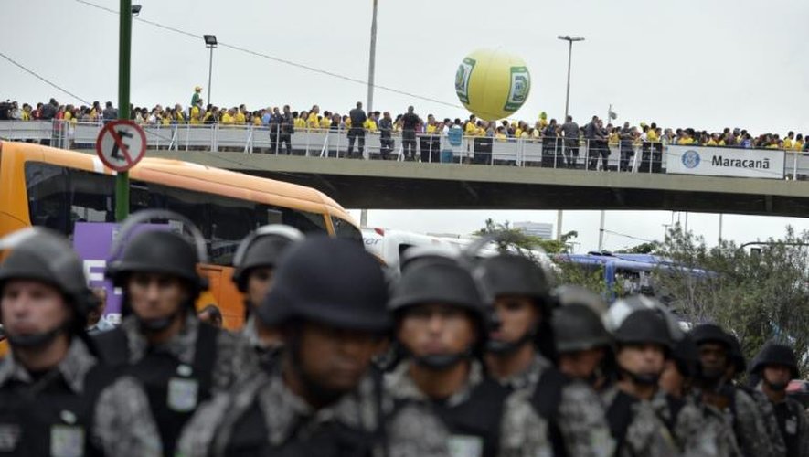 Des supporteurs arrivent au stade du Maracana, le 30 juin 2013 à Rio de Janeiro, cerné par la police