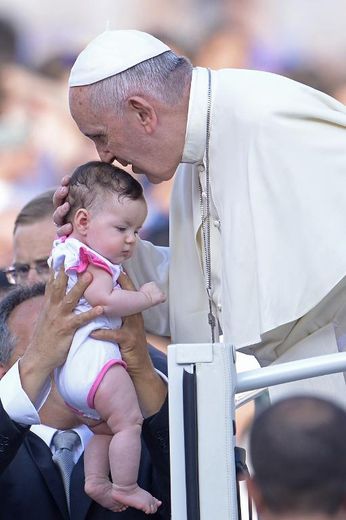 Le pape François bénit un bébé en arrivant sur la place Saint-Pierre du Vatican le 14 juin 2015