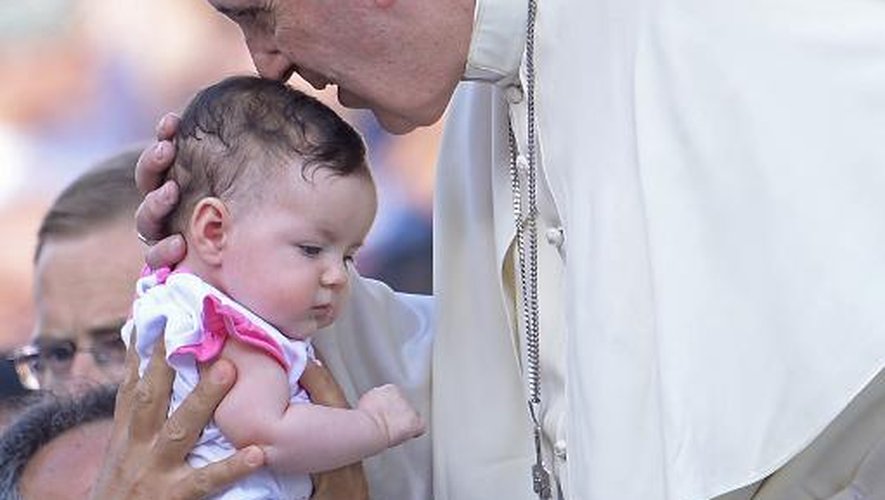 Le pape François bénit un bébé en arrivant sur la place Saint-Pierre du Vatican le 14 juin 2015