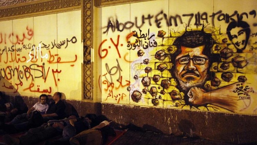 Graffiti dans les rues du Caire représentant le portrait du président Morsi frappé par un coup de point, le 1er juillet 2013