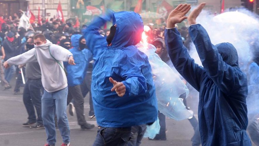 Des manifestants lancent des projectiles contre la police, le 12 avril 2014 à Rome
