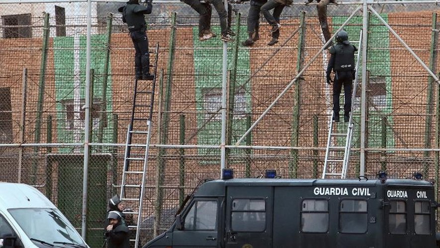 Des membres la Garde civile espagnole tente de déloger des migrants de la barrières séparant l'enclave espagnole de Melilla du Maroc, le 19 février 2015